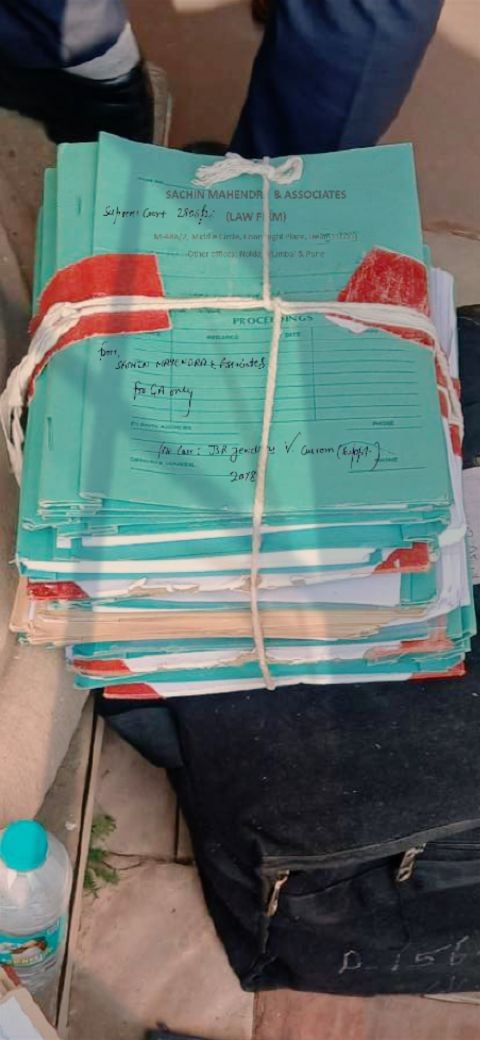 A stack of legal proceeding files of Sachin Mahendra & Associates tied with string