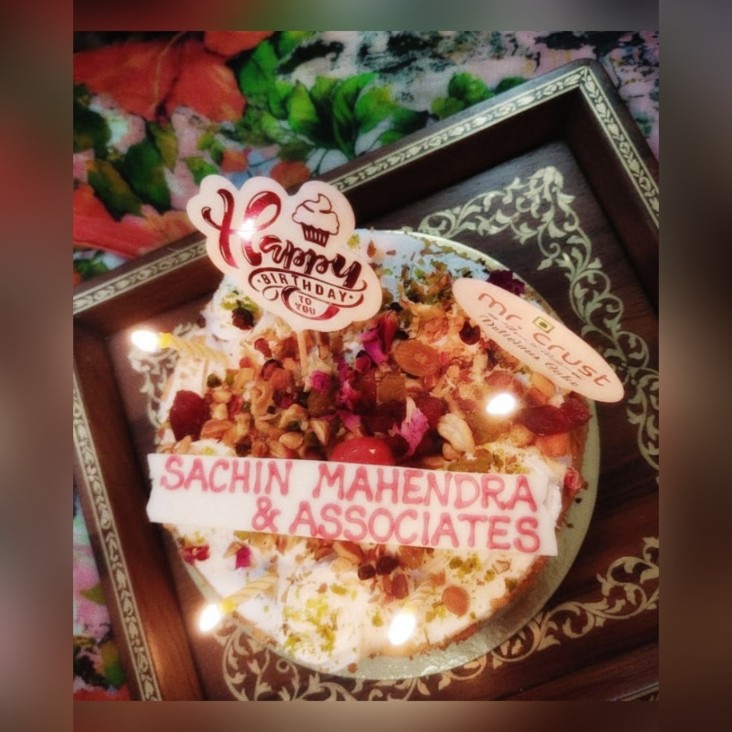 A birthday cake reading Sachin Mahendra & Associates with candles