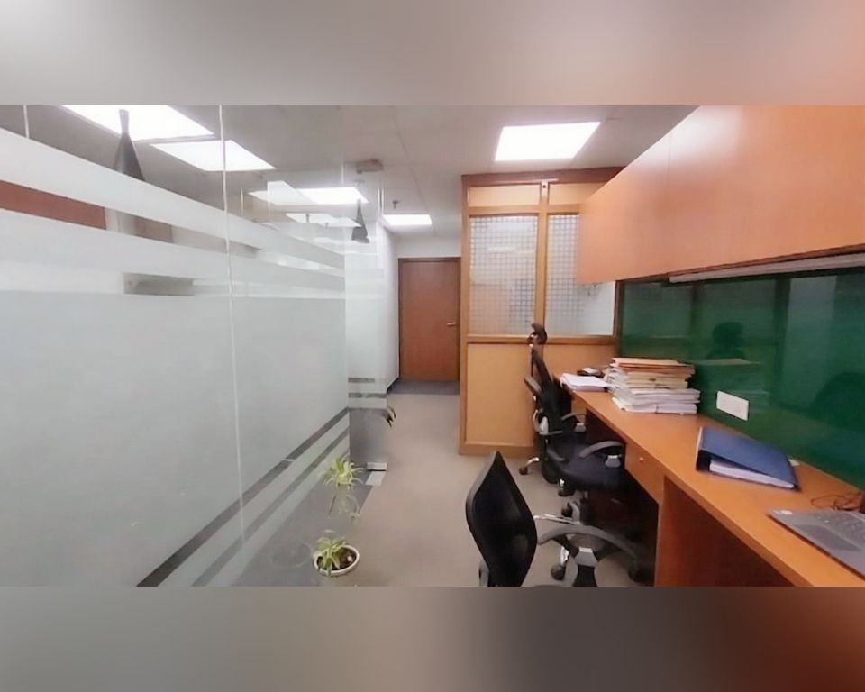 Glass-partitioned office cabins with desks and chairs