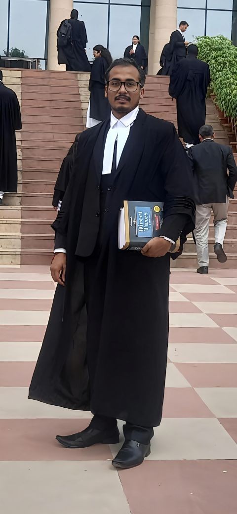 Founder in advocate robes holding a Direct Taxes book on the court steps